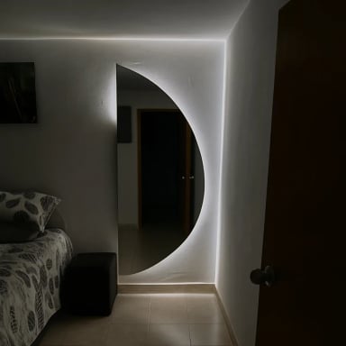 Stylish modern mirror with soft lighting in bedroom.