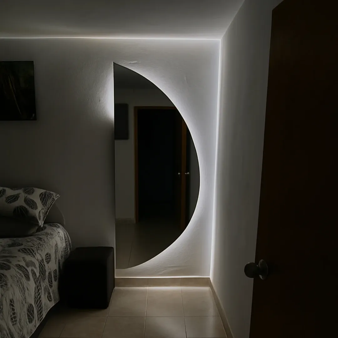 Stylish modern mirror with soft lighting in bedroom.